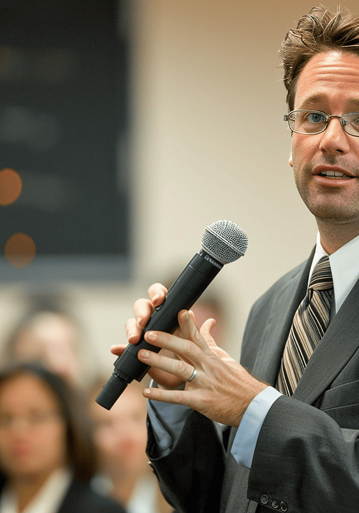 Hombre hablando con micrófono en un evento.