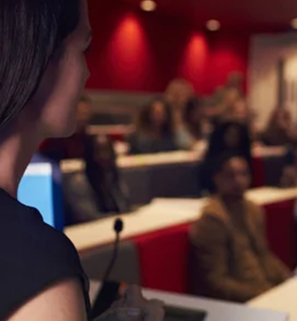 Mujer presentando ante una audiencia interesada.